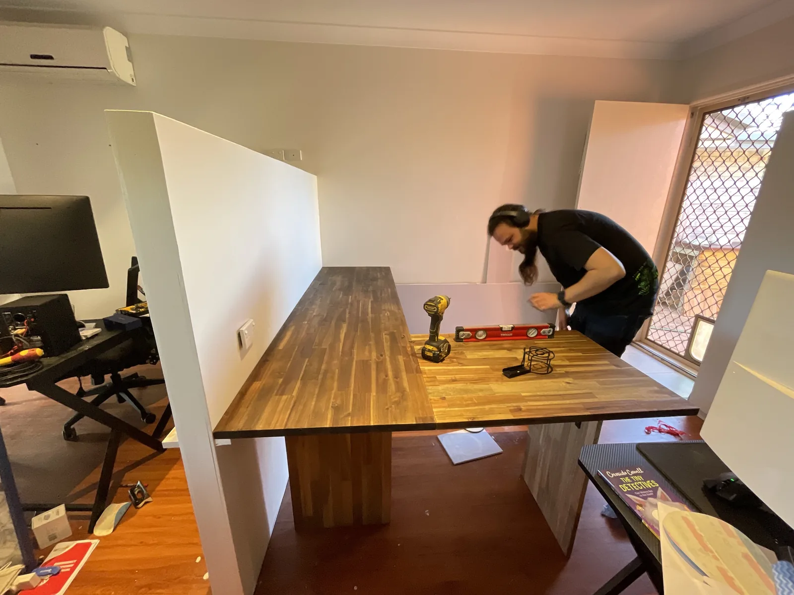 A Cyberry team member levelling a new timber desk while fitting out the first office