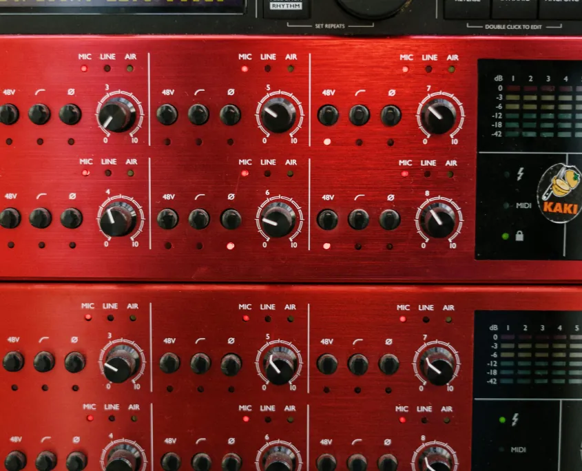 Red rack-mounted audio amplifiers and processors in a venue AV install