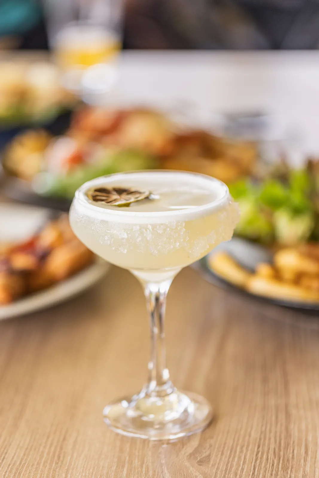 Salt-rimmed cocktail photographed among share plates at Club Lennox